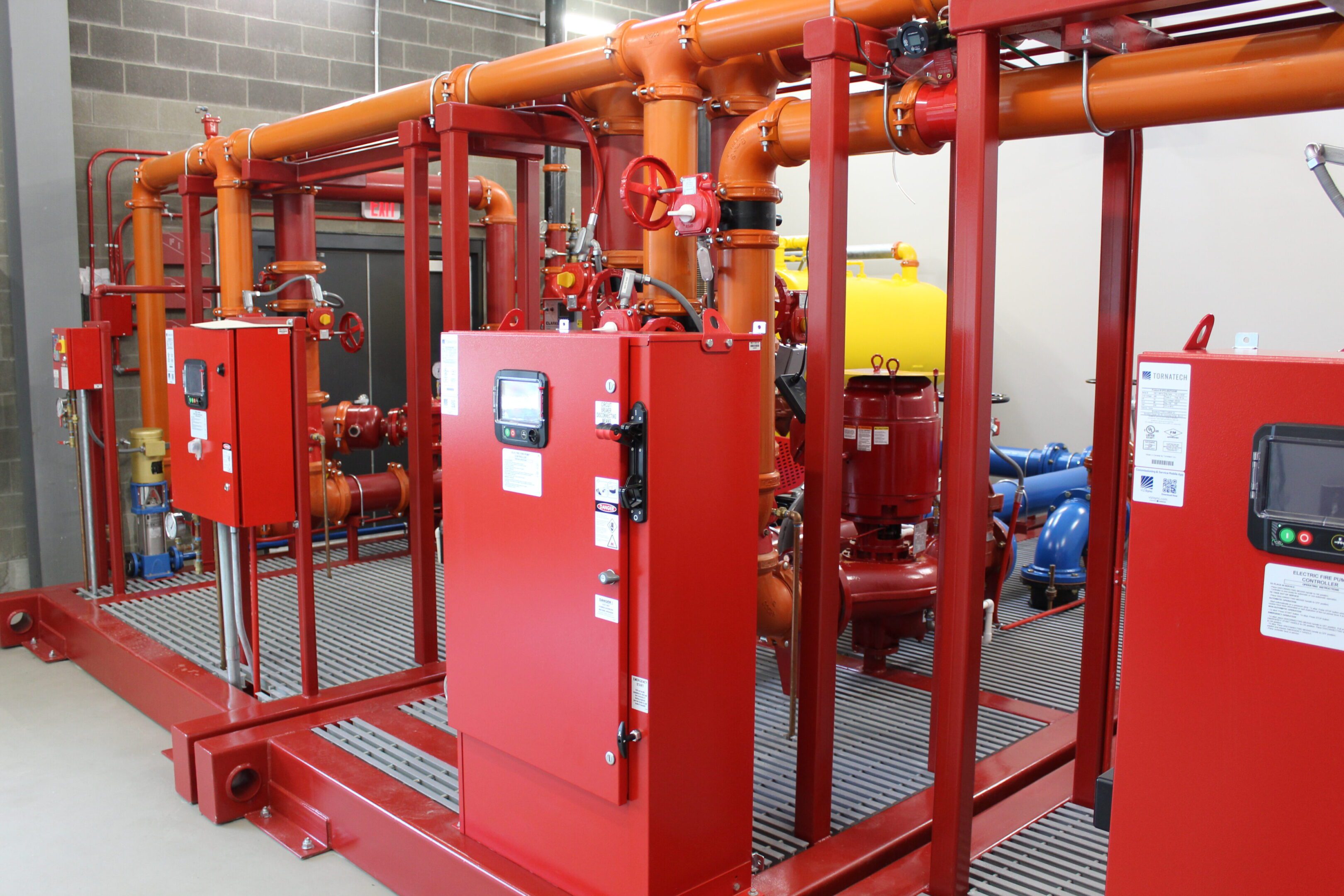 A red machine with pipes and valves in the background.