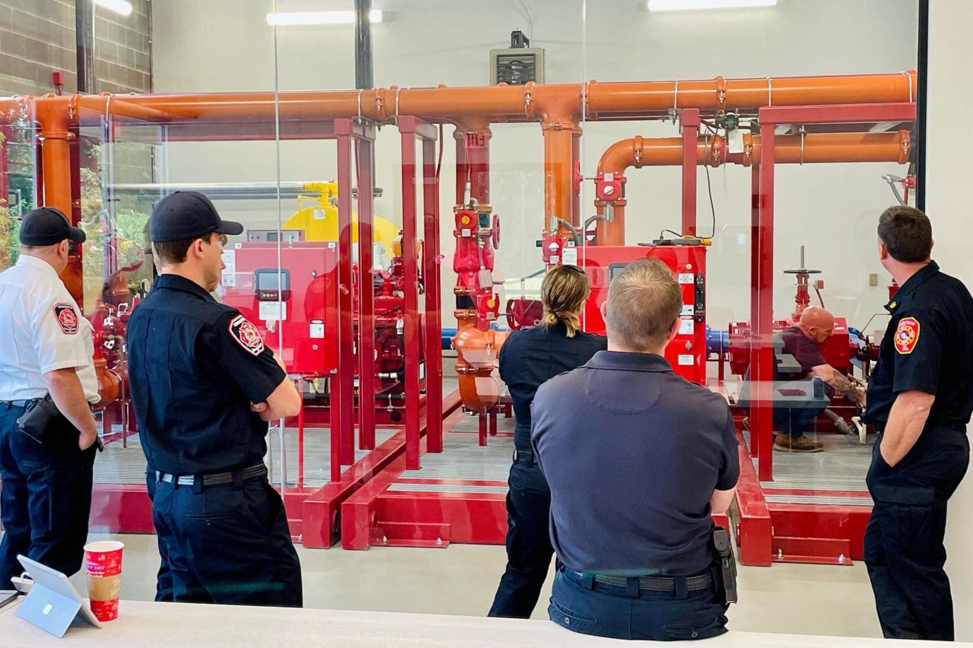Two men in uniform are looking at a fire hydrant.