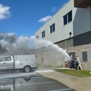 A person is spraying water from the back of a truck.