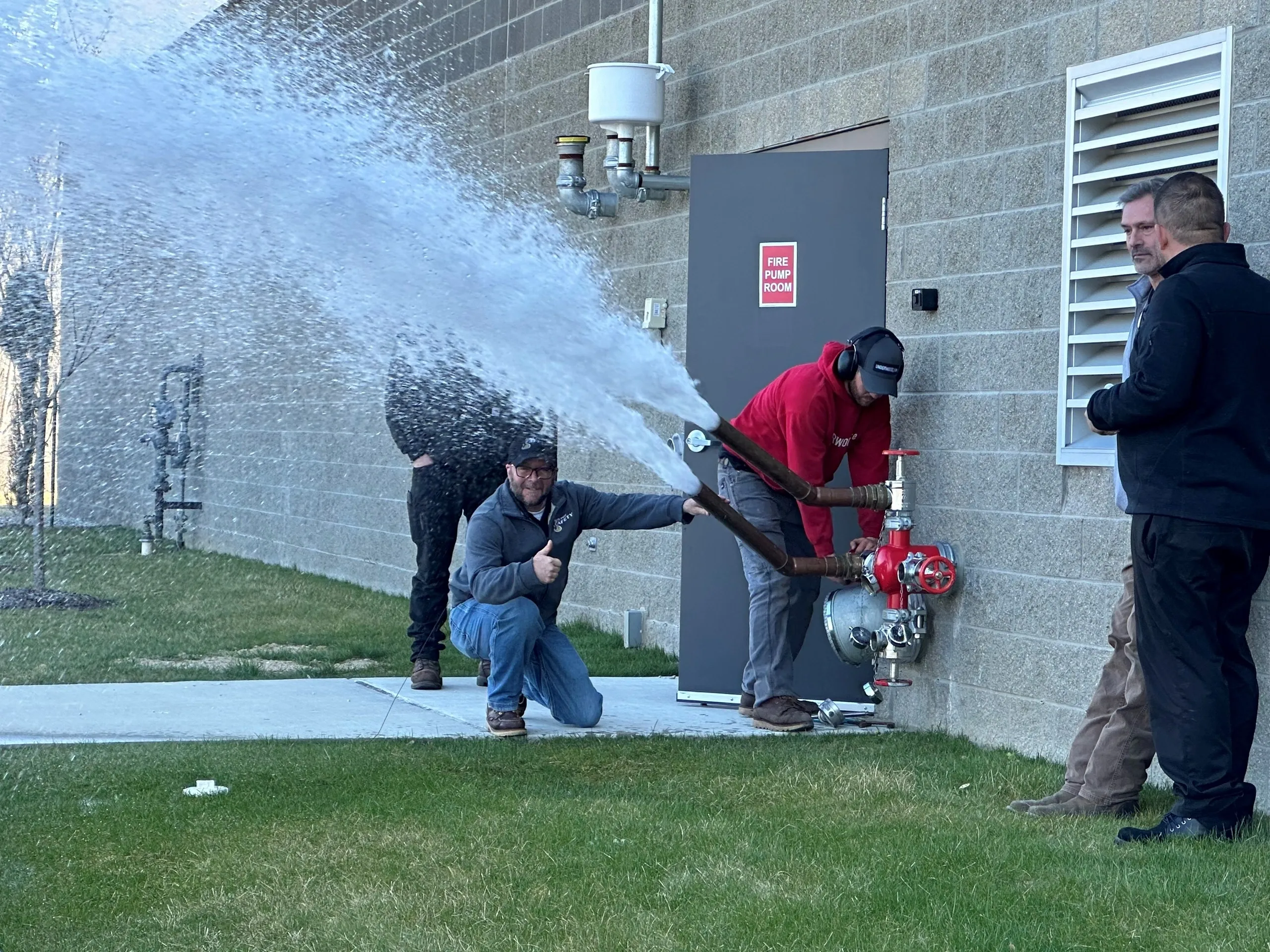 A group of people that are standing in front of a fire hydrant.