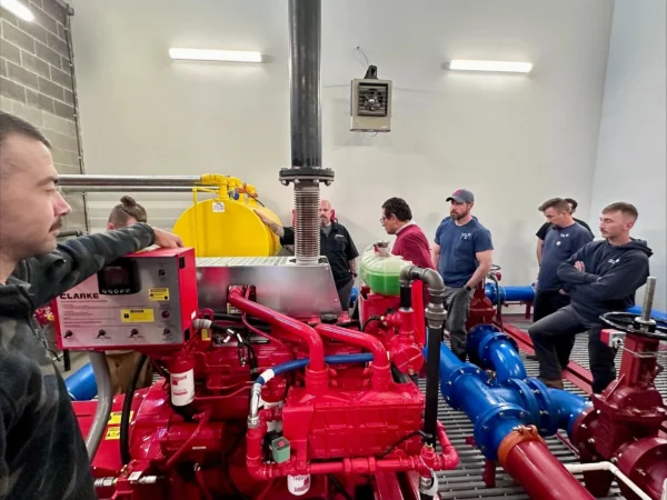 A group of people standing around a red machine.